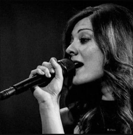 Anna durante un'esibizione vocale dal vivo al microfono